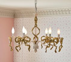 a chandelier hanging from the ceiling in a room with pink walls and wallpaper