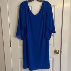 a blue dress hanging up on a door