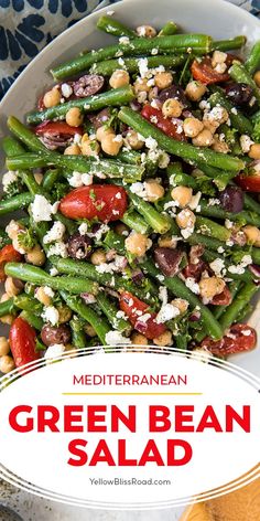 green bean salad with tomatoes, olives and feta cheese in a white bowl