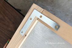 a close up of a wooden frame with metal hardware