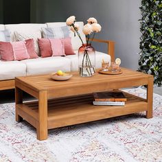 a living room filled with furniture and flowers on top of a rug in front of a couch