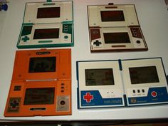 four different game systems sitting on top of a white table with orange and blue trim