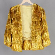 a gold jacket is hanging on a hanger and it has fringes all over it