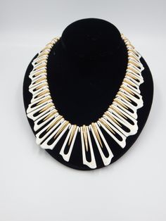 "Phenomenal vintage Monet 1970s statement necklace. The name of the collect was \"Fantasie\" and was manufactured in 1977. Monet featured the white enamel style in the ads featuring the top models of that era. This necklace is incredible. White enameling is accented by gleaming free-form gold-plated drops. The collar necklace has an Egyptian style essence. Condition is good. As shown in the photos, there are flea bites and some dirt that is consistent with wear and age. There is a metal Monet ha White Metal Costume Jewelry Necklace, Vintage White Necklace, Vintage White Metal Jewelry, Collectible White Jewelry, Vintage White Enamel Necklaces, White Retro Enamel Jewelry, Retro White Enamel Jewelry, Collectible White Metal Jewelry, Egyptian Collar