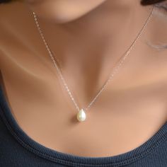 "You can't go wrong with the classic pearl drop necklace. This simple teardrop design will go with everything and is pretty enough for special occasions as well. A creamy white, genuine teardrop pearl slides freely along sterling silver chain in this floating pearl necklace. This lovely pearl is a full drop shape and measures approx. 13mm tall x 9mm wide. Tiny white pearls connect the sterling silver lobster clasp. Simply elegant, and perfect for the bride who wants a minimalist, classic piece o Pear-shaped Pearl Drop Necklaces, Elegant Pearl Teardrop Necklace With Delicate Chain, Elegant Teardrop Pearl Necklace With Delicate Chain, Elegant Teardrop Pendant Drop Necklace With Pearl, Teardrop Pearl Chain Necklace, Pearl Drop Teardrop Necklace, Minimalist Teardrop Pearl Chain Drop Necklace, Elegant Teardrop Drop Necklace With Pearl Charm, Pearl Drop Necklace As Gift