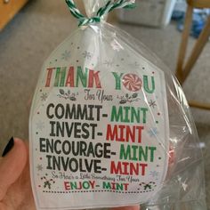 a hand holding up a plastic bag that says thank you for your commit - mintt