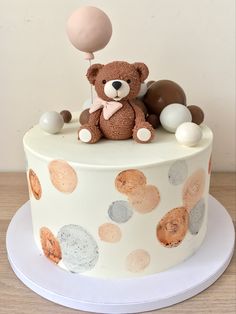 a teddy bear sitting on top of a white cake