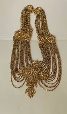 "MONET gold plated festoon chain statement necklace  Excellent condition, made in 1969 marked: Monet copyright symbol  all sizes approximately:  16.75\" long with clasp and the center is 4 1/4\" including dangles.  Domestic shipping: USPS First class mail. 1-5 business days. I can file an insurance claim only after 20 business days after item was shipped International shipping: USPS First class mail. Approximately 7-21 business days. I can file an insurance claim only after 40 business days afte Luxury Handmade Gold Long Necklace, Luxury Yellow Gold Drop Necklace With 17 Jewels, Vintage Gold Chain Necklace For Party, Antique Gold Dangle Necklaces, Gold Costume Jewelry Necklace With Intricate Design, Gold Filigree Dangle Necklaces, Ornate Gold Necklace For Party, Ornate Gold Party Necklace, Copyright Symbol