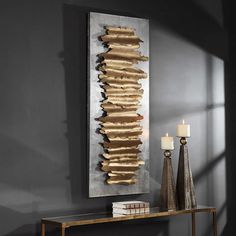 a console table with two candles and a painting on the wall behind it in a dark room