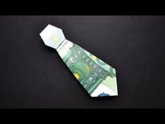 an origami tie made out of money on a black surface with space for text