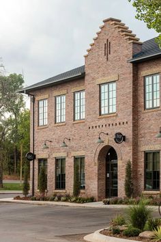 a brick building with several windows and signs on the front