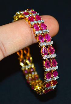 "1 solid 18k gold 10.35cts diamond and ruby bangle f-g color and vs clarity untreated natural diamonds and untreated natural pinkish red rubies. extremely high end - top quality bangle (i have 2 bangles, but this listing is of one bangle. please contact me if you are interested in both bangles) here is the description of one bangle: this is a custom made top quality ruby and diamond bangle. the bangle is loaded with 1.71cts of round brilliant cut diamonds and 22 pear cut natural red rubies total Elegant Diamond Bangle With Gemstones, Fine Jewelry Diamond Bangle With Prong Setting, Diamond Bangle In Yellow Gold For Party, Yellow Gold Diamond Bangle For Party, Diamond Bangle With Prong Setting, Party Yellow Gold Diamond Bangle, Diamond Prong Setting Bangle Gift, Diamond Bangle With Prong Setting Gift, Diamond Bangle With Single Cut Diamonds