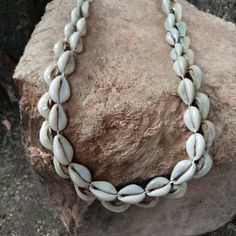 This listing is for an original handmade Cowrie / Cowry shell Turkana tribe unisex 2-strand necklace.  Each is made in the Lokitaung region near Lake Turkana, Kenya...located just south of Ethiopia.  Made from traditional cowry shells & white poly-cord from a gurney sack.  Item measures appx: 18-30 Inch total length.  YOU SELECT LENGTH AT CHECKOUT. CONTINUOUS 2-LAYER,... item as shown.  Weight is appx: 80-150 grams.   --Striking piece matches anything and looks great on anyone, anytime,... anypl Traditional Shell-shaped Beach Jewelry, Traditional Shell Jewelry For Beach, Handmade Bohemian Shell Choker, Artisan Fair Trade Necklaces For Beach, Bohemian Handmade Shell Choker, White Handmade Artisan Shell Necklace, Handmade Bohemian Cowrie Shell, Bohemian Handmade Cowrie Shell, Artisan Handmade Necklaces For Beach