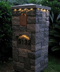 a stone mailbox is lit up with lights