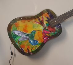 a guitar shaped like a heart with a hummingbird painted on it