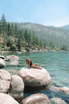 a woman laying on rocks in the water