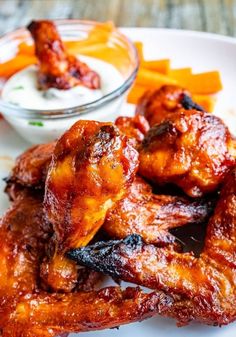 chicken wings and carrots on a plate with ranch dressing