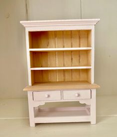 a small white bookcase with two drawers