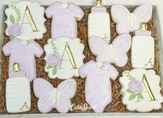 decorated cookies in the shape of baby's first and second birthday items are arranged in a box