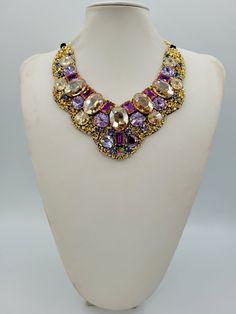 Each piece of our statement necklaces is handmade and one of a kind made in Italy. Our creations is made of high quality materials such as crystals and rhinestones. Each embroidered material is carefully hand sewn. Very glamorous and stylish. Perfect gift to someone you like. Materials Strass stone and Rhinestone in Violet, Crystal Golden Shadow and Violet Blue color in different dimension.  Black satin fabric backing. Aluminium chain with lobster closure. Measurements Weight approximate 200 grams. Chain lenght 25 cm - 9.84 in Circumference approximate 63 cm - 24.80 in Feel free to contact us if you have any question. Thank you so much for looking at our shop and our articles each of them, single piece. Crystal Jeweled Necklaces For Celebration, Costume Jewelry Jeweled Choker Necklace, Luxury Jeweled Choker Necklace, Gold Rhinestone Necklaces For Celebration, Gold Crystal Embellished Choker Necklace, Luxury Jeweled Bridal Necklace Gift, Crystal Stone Necklaces In Costume Jewelry Style, Gold Crystal Necklaces With Stones For Party, Luxury Crystal Necklace With Stones