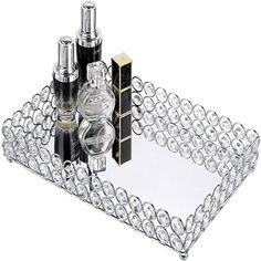 a clear glass tray with perfume bottles on it