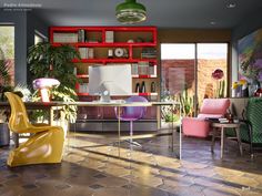 an office with colorful furniture and plants in it