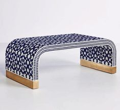 a blue and white bench sitting on top of a white floor