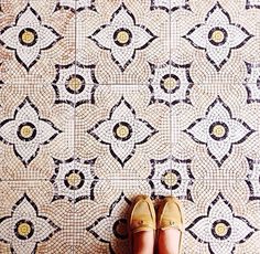 a pair of shoes sitting on top of a tiled floor