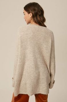 So chic and effortless, this slouchy, oversized tunic-style sweater features a v-neckline and dropped wide sleeves for added shape. -Available in Stone & Misty Blue -Waffle textured -V-neck -Oversized fit -Soft touch eyelash two tone yarn -Long sleeve with folded cuffs -Side slits -Ribbed on hem -Content: 74% Acrylic 22% Polyester 4% Lycra -Hand was cold/Line dry -Imported -Model is 5 8" 32-24-34 and wearing a size Small Oversized V-neck Sweater For Layering, Oversized Chic V-neck Sweater, Oversized V-neck Sweater For Fall, Oversized V-neck Chic Sweater, Oversized Knit V-neck Sweater With Long Sleeves, Oversized V-neck Sweater For Loungewear, Oversized Chic Sweater With Ribbed Neckline, Chic Oversized V-neck Sweater For Loungewear, Cozy Oversized V-neck Sweater With Long Sleeves