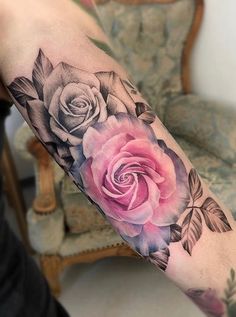 a woman's arm with roses and leaves on it