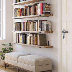 the bookshelf is filled with many different types of books and there are two benches in front of it