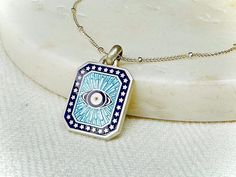 Infused with ancient symbolism and hand crafted with love, this turquoise and deep blue Evil Eye Pendant embodies both protection and style. The pendant is handmade and enamelled in my studio in turquoise and deep blue hues. The ancient art of enamelling meets contemporary design - I carefully layer and fuse glass to the fine silver with fire, creating a vibrant and eye-catching piece. The Evil Eye has been a symbol of protection throughout history and across cultures, worn to ward off bad energy and bring luck and good fortune. A talisman that transcends time, it adds a touch of spirituality to your everyday style. The back of the pendant, a canvas for personalization, allows you to engrave a meaningful message, turning it into a cherished keepsake. The customizable enamel colours ensure Bad Energy, Protection Amulet, Amulet Necklace, Meaningful Messages, Blue Evil Eye, Eye Pendant, Evil Eye Pendant, Eye Protection, Blue Turquoise