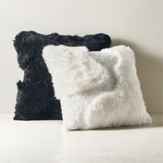 two black and white pillows sitting next to each other