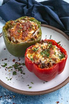 two stuffed peppers sitting on top of a white plate next to each other with toppings