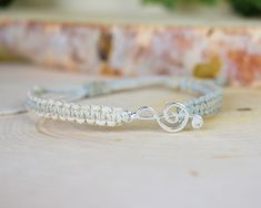 "--- ABOUT THIS BRACELET: This bracelet features a sweet, silver or gold toned treble clef charm, centered in a hand-knotted hemp band in your choice of color. It is finished with an adjustable slide knot closure to ensure the most comfortable fit. Your bracelet will be brand new and handmade-to-order, just for you! --- HEMP COLOR: Choose one from the list of colors. The featured color is Black. Examples of the other colors are in the last pictures. --- CHARM COLOR: Antique silver tone, bright s Music Bracelet, Musician Gifts, Piano Teacher, Treble Clef, Cadiz, Music Lover, Piano Music, Braided Bracelets, Music Lovers