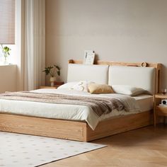 a large bed sitting next to a window in a bedroom on top of a hard wood floor