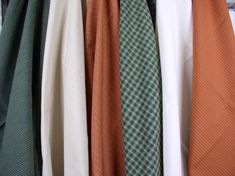 several different colored ties hanging on a rack