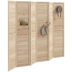 a room divider made out of woven wicker with hooks on the door and purses hanging from it