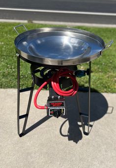 a large metal pan sitting on top of a table with a hose attached to it