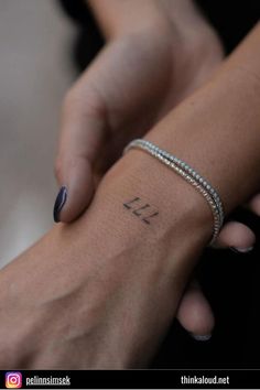 two hands holding each other with the word love tattooed on their wrist and bracelets