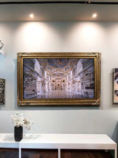 a painting hanging on the wall above a white table