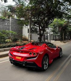 a red sports car driving down the street