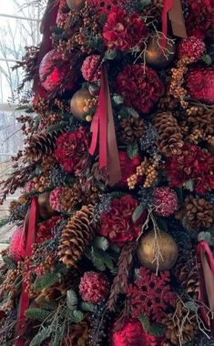 a christmas tree decorated with pine cones and red ribbon