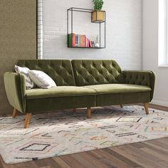 a yellow couch sitting on top of a wooden floor next to a book shelf filled with books