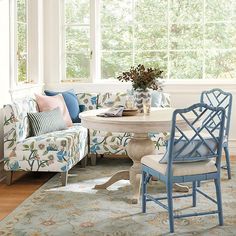 a living room filled with furniture and a round table surrounded by pillows on top of a rug