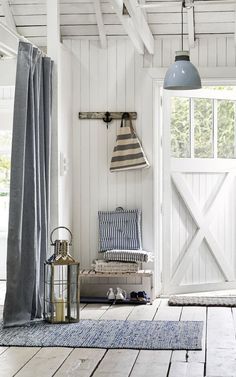 a room with white walls and wooden flooring has a blue rug on the floor