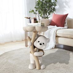 a table with a monkey on it in front of a couch and a potted plant