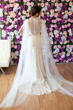 the back of a bride's dress in front of a floral wall