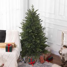 a small christmas tree in the corner of a living room with presents on the floor