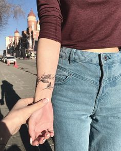 two people holding hands while walking down the street